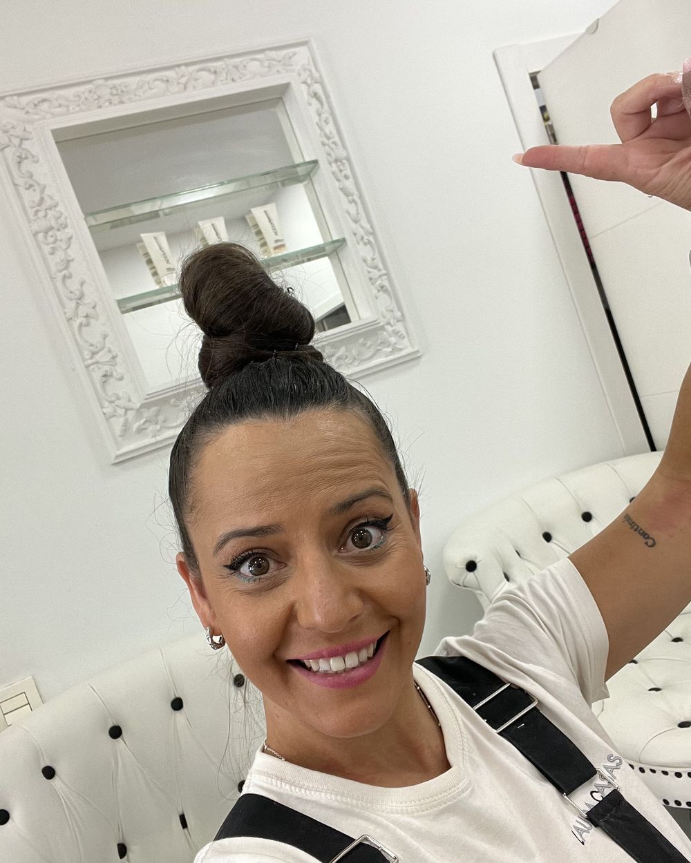 Laura Casas en su salón señalando hacia arriba